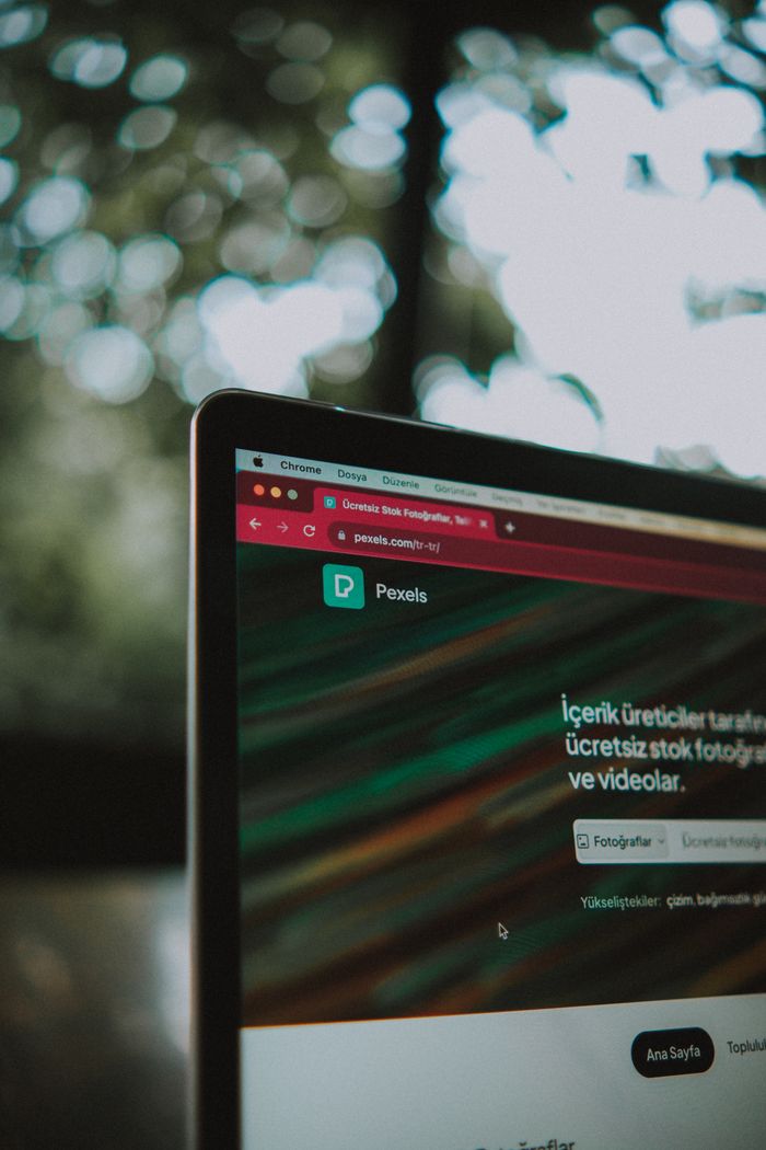 creative-01 Close-up of a laptop screen with the Pexels website open, showcasing a vibrant bokeh background.